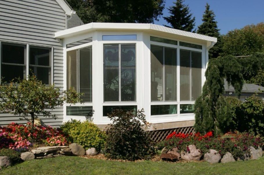 A house with a screened in porch on the side of it