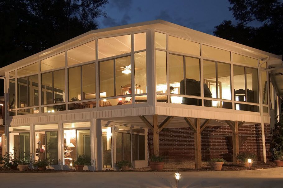 A large house with a lot of windows is lit up at night.