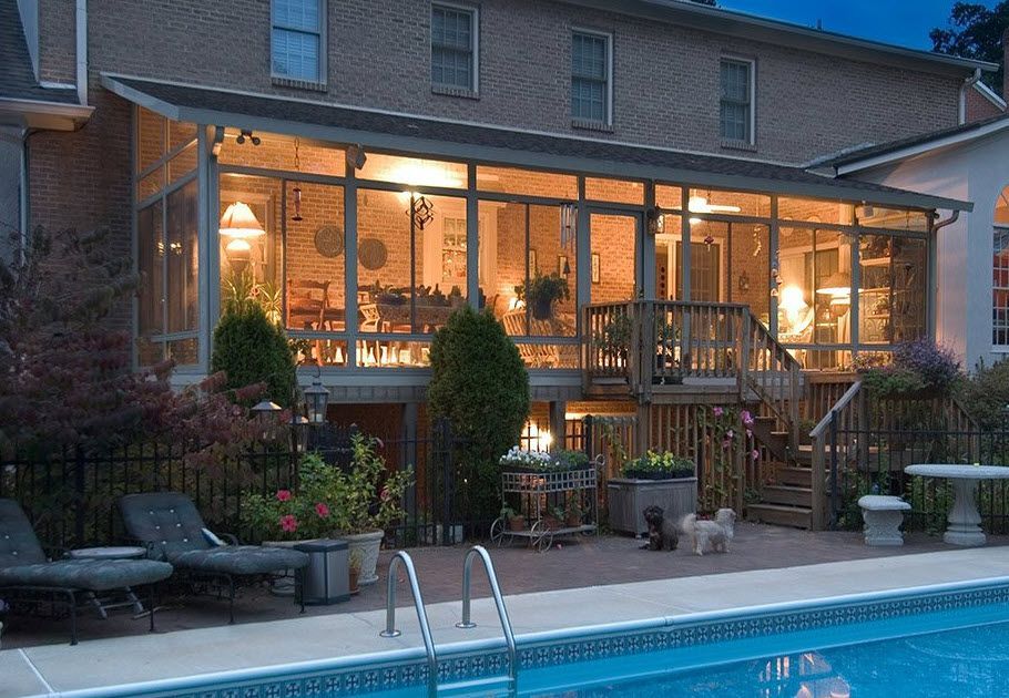 A large house with a swimming pool in front of it