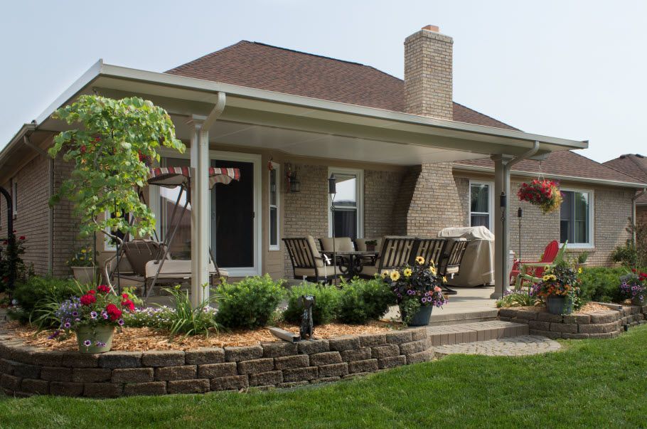 A brick house with a covered porch and patio area