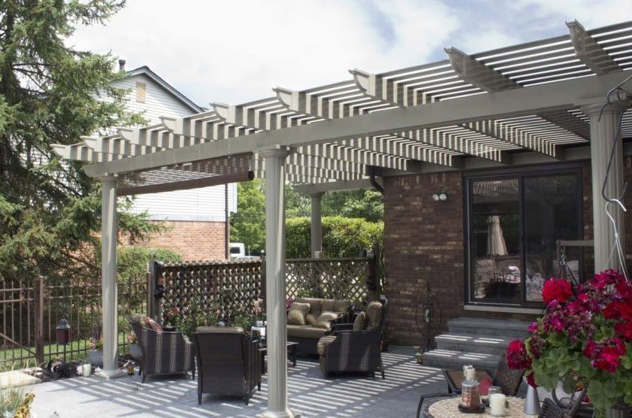 A patio with a pergola and chairs and a table