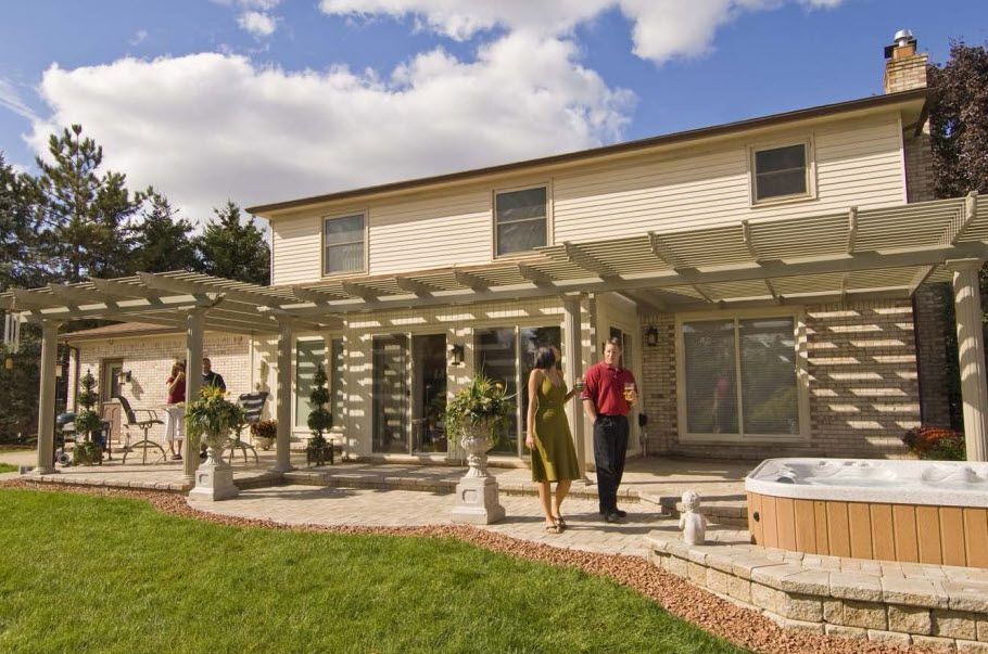 A couple walking in front of a house with a hot tub