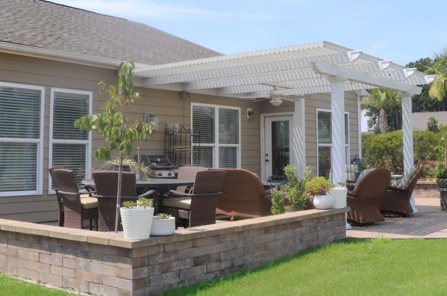 A house with a patio area and a pergola in front of it.