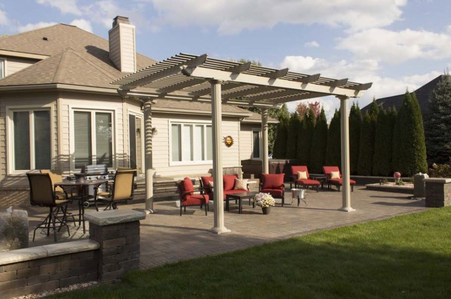 A house with a pergola and patio furniture in front of it