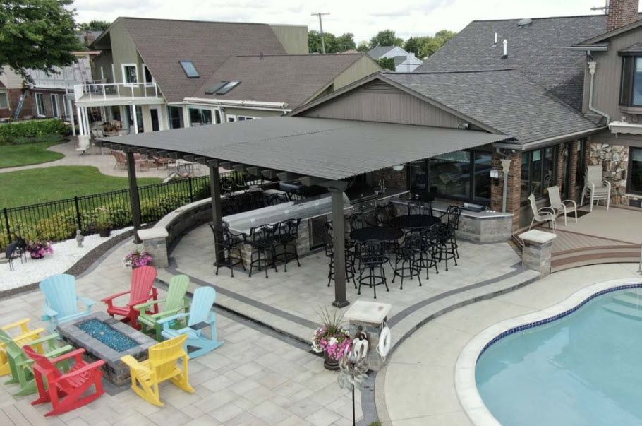 An aerial view of a patio with a pool and tables and chairs.