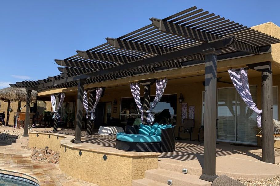A house with a pergola and a pool in front of it.