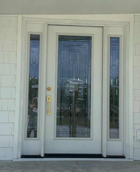 A white door with a reflection of a building in the glass