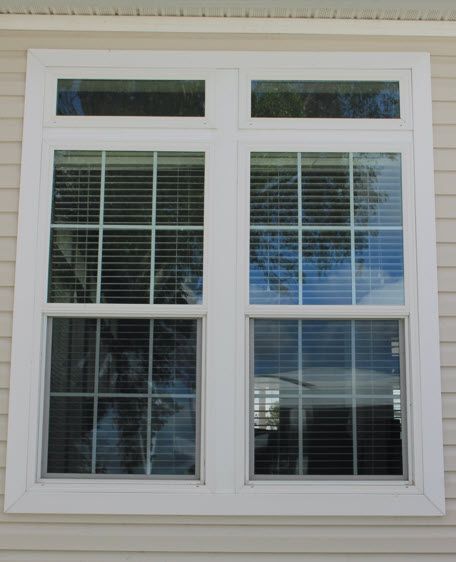 A house with two windows with blinds on them