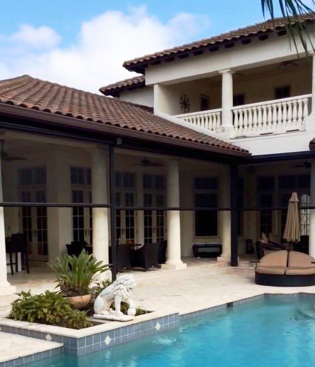 A large house with a swimming pool in front of it