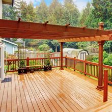 A wooden deck with a pergola over it