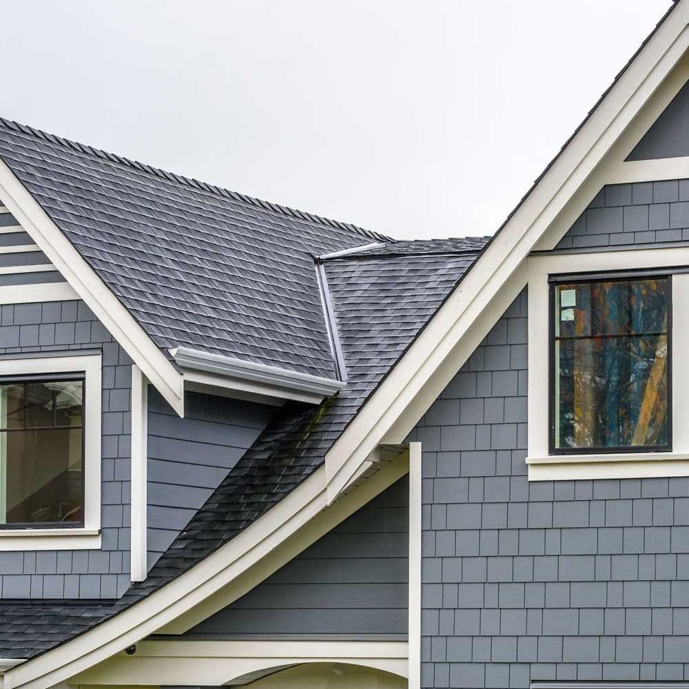 A gray house with a black roof and white trim