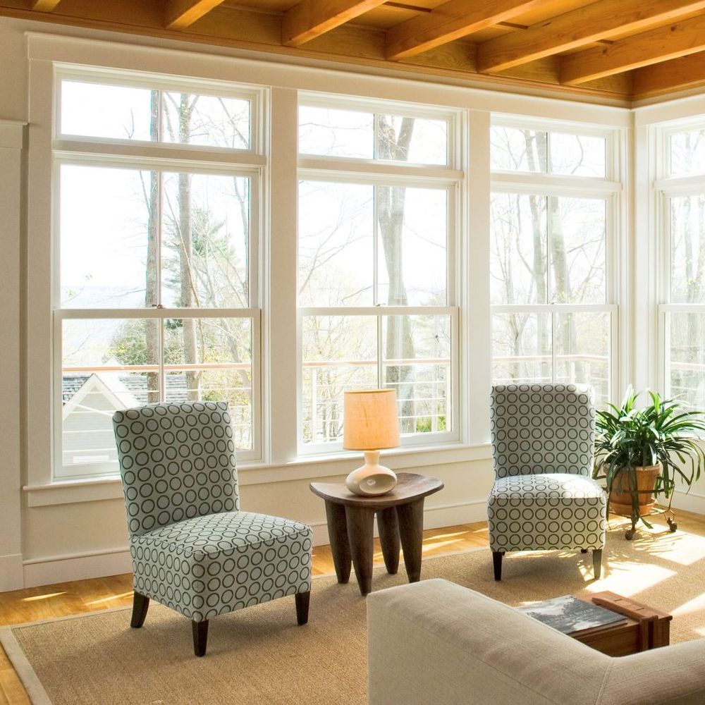 A living room with two chairs a table and a lamp