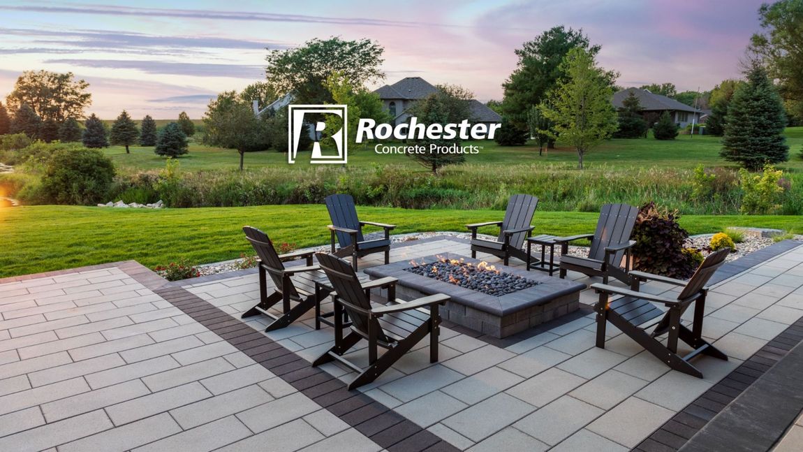 Patio seating overlooking a green park at sunset, with Rochester logo in the sky.