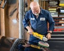 Image of an older man working on a car.