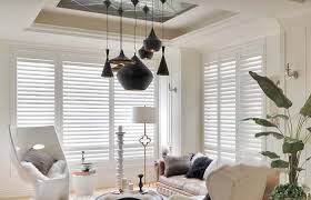 Interior with open wood shutters, a window, and wooden cabinets.