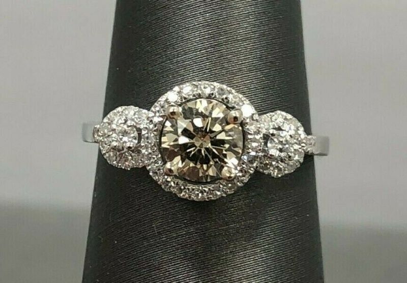 A diamond ring is sitting on a black ring holder.