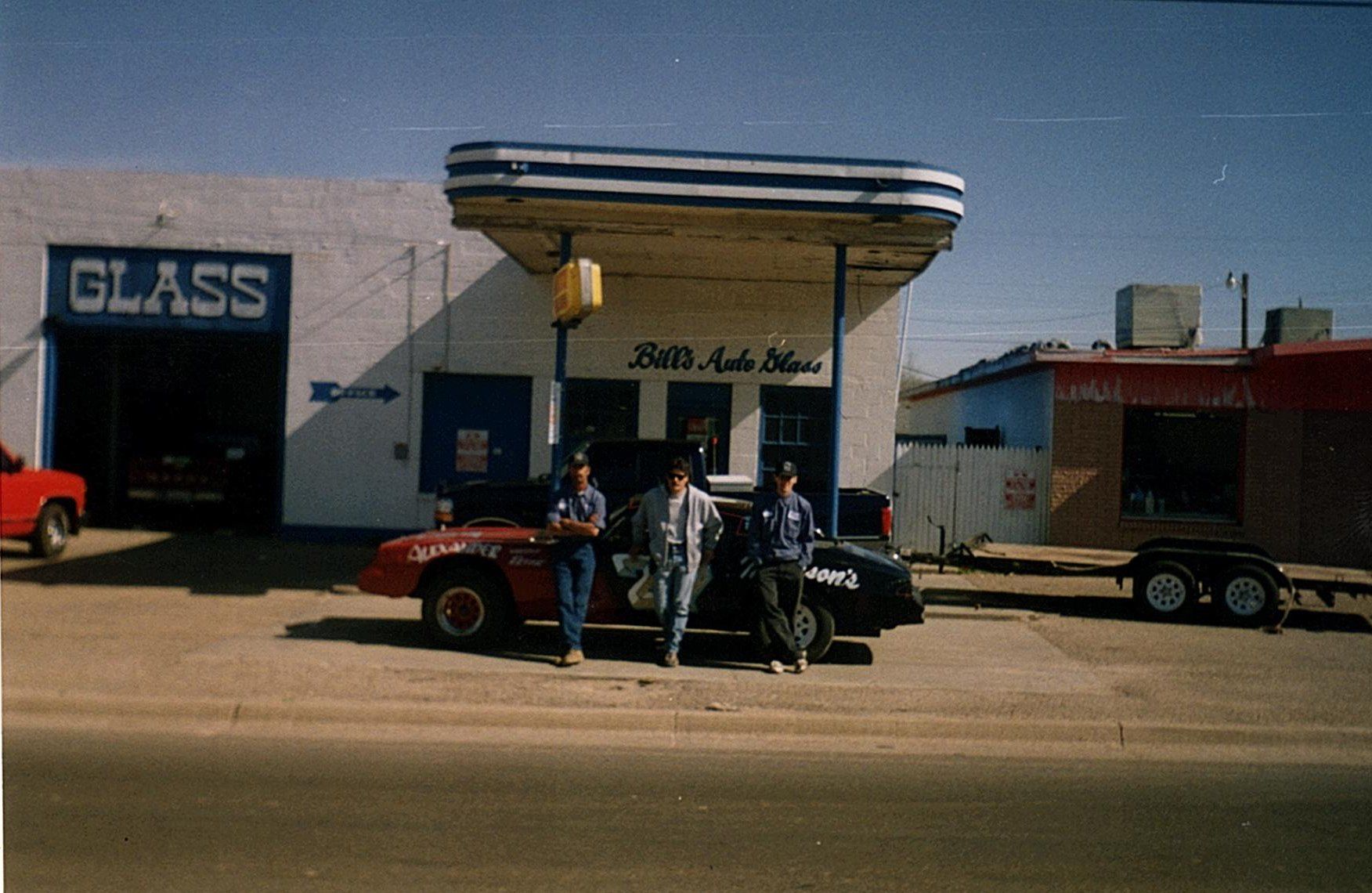 A group of people standing in front of the old Bill's Auto Glass building