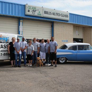 A group of people standing in front of Bill's Auto Glass
