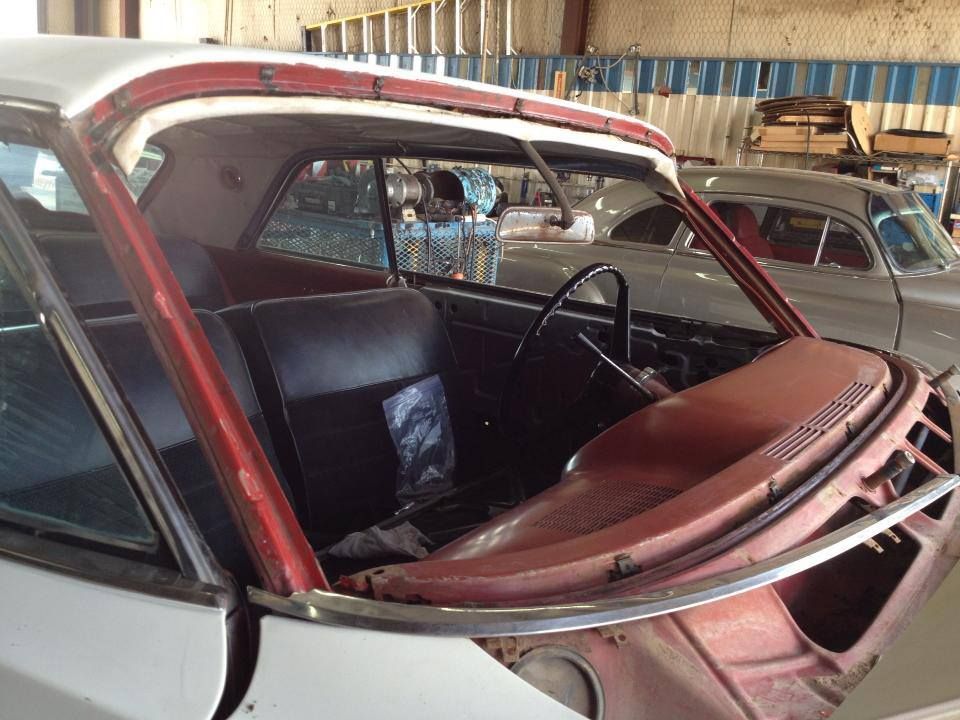 A car with a broken windshield is sitting in a garage.