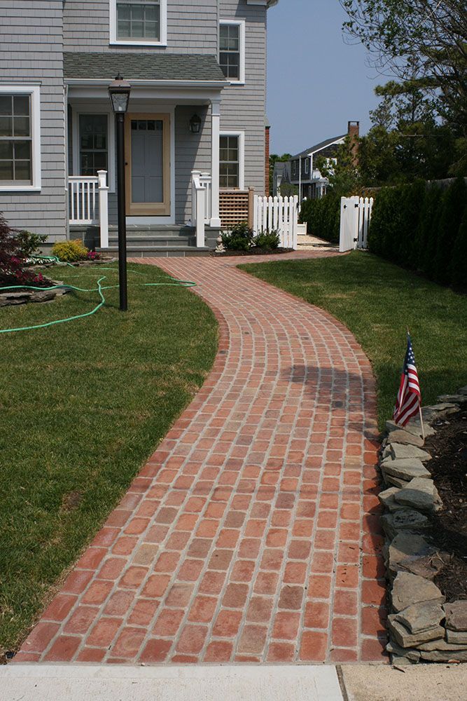 A brick walkway leads to the front door of a house