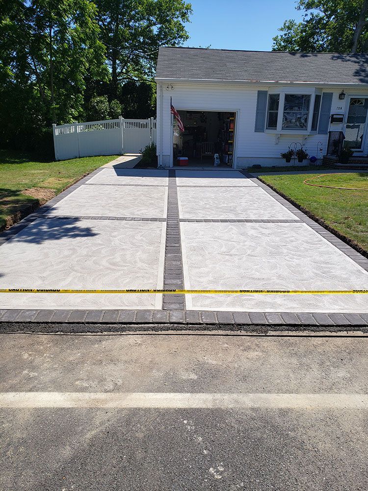 A concrete driveway is being built in front of a house