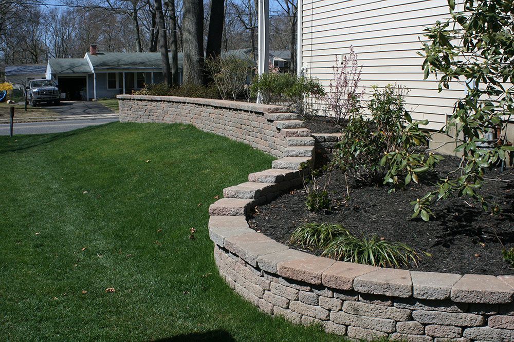 A house with a brick wall in front of it