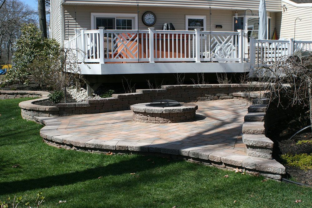 A house with a deck and a fire pit in the backyard