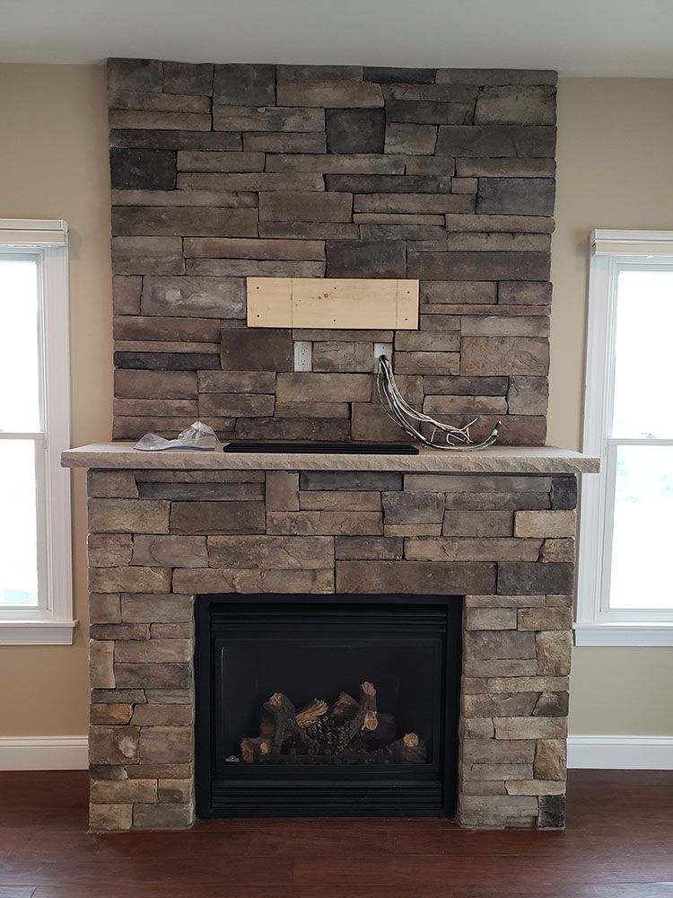 A stone fireplace with a wooden sign above it