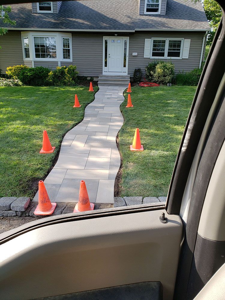 A view of a walkway in front of a house from inside a car
