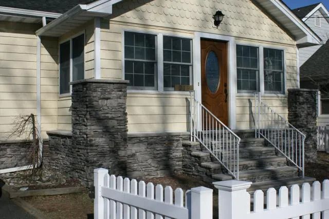 A house with stairs and a white fence