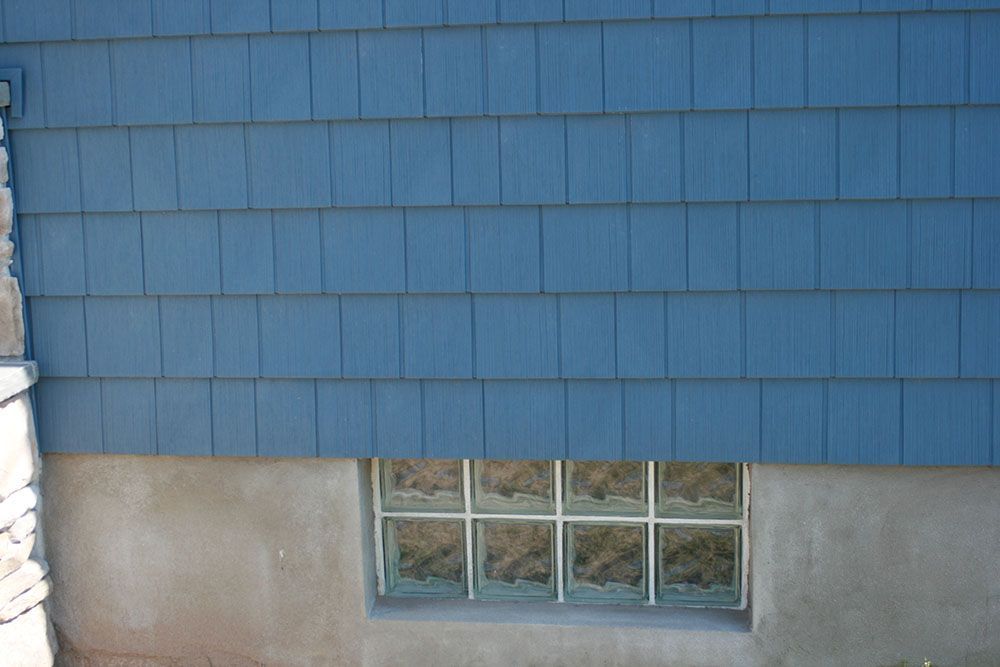 A blue house with a window in the basement