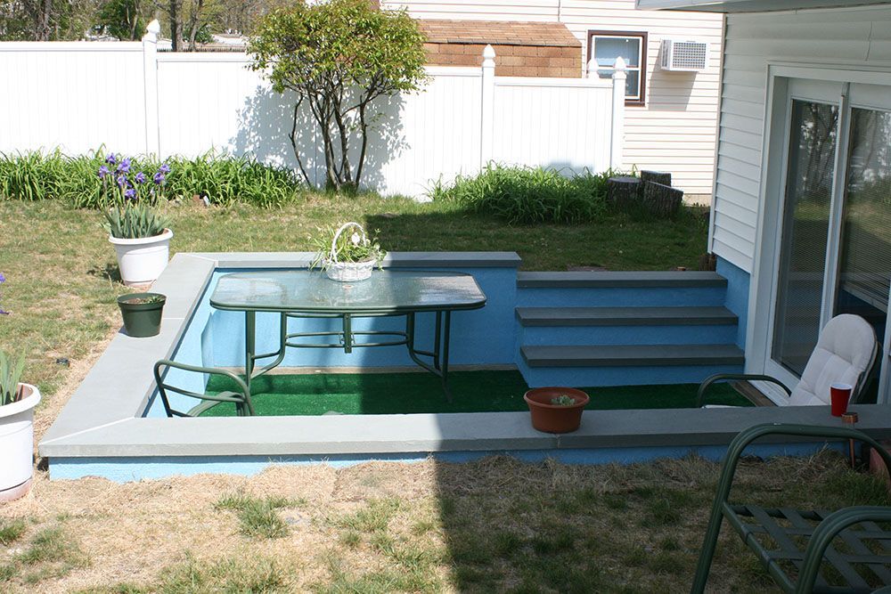 The backyard of a house with a table and chairs