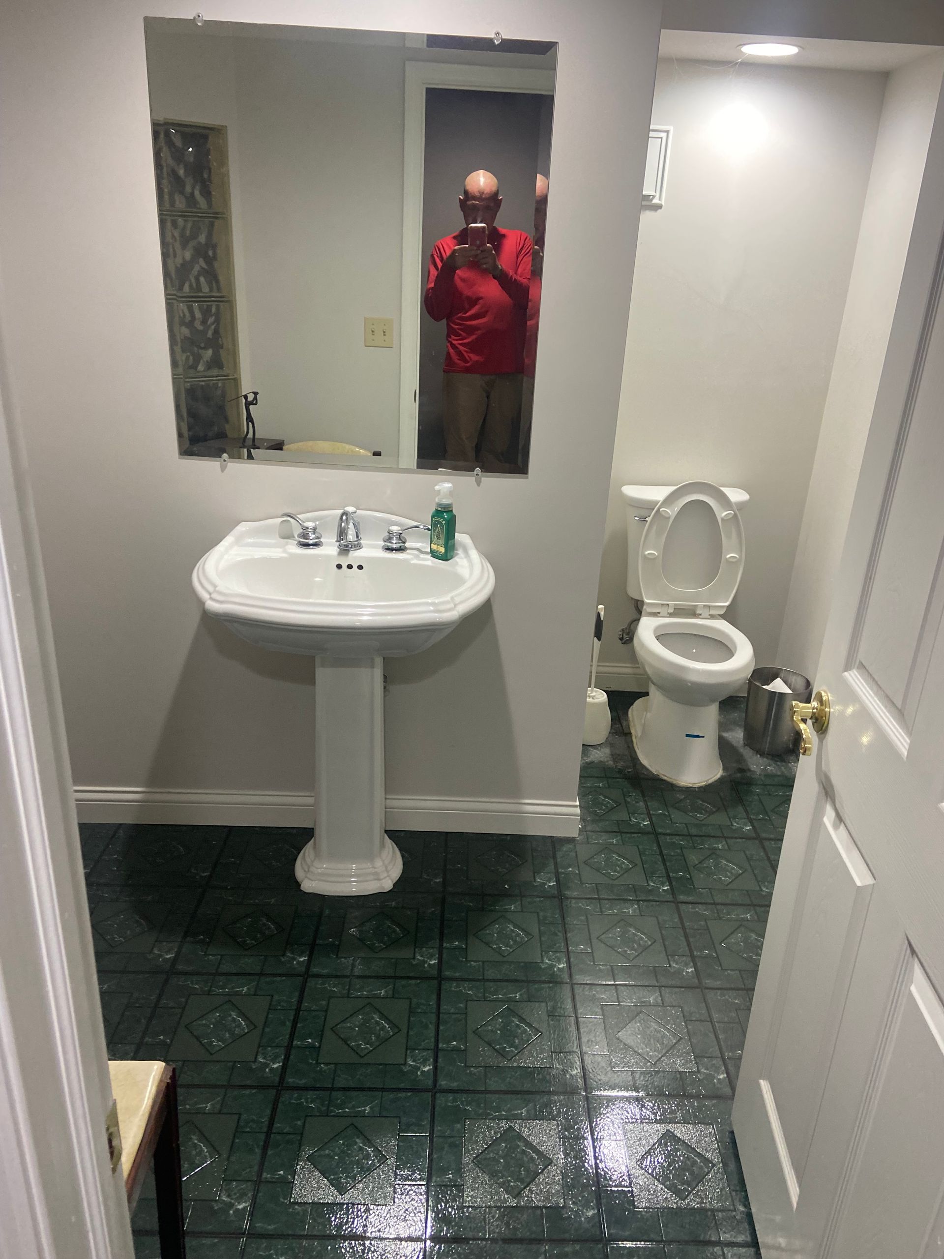 A bathroom with a sink , toilet and mirror.