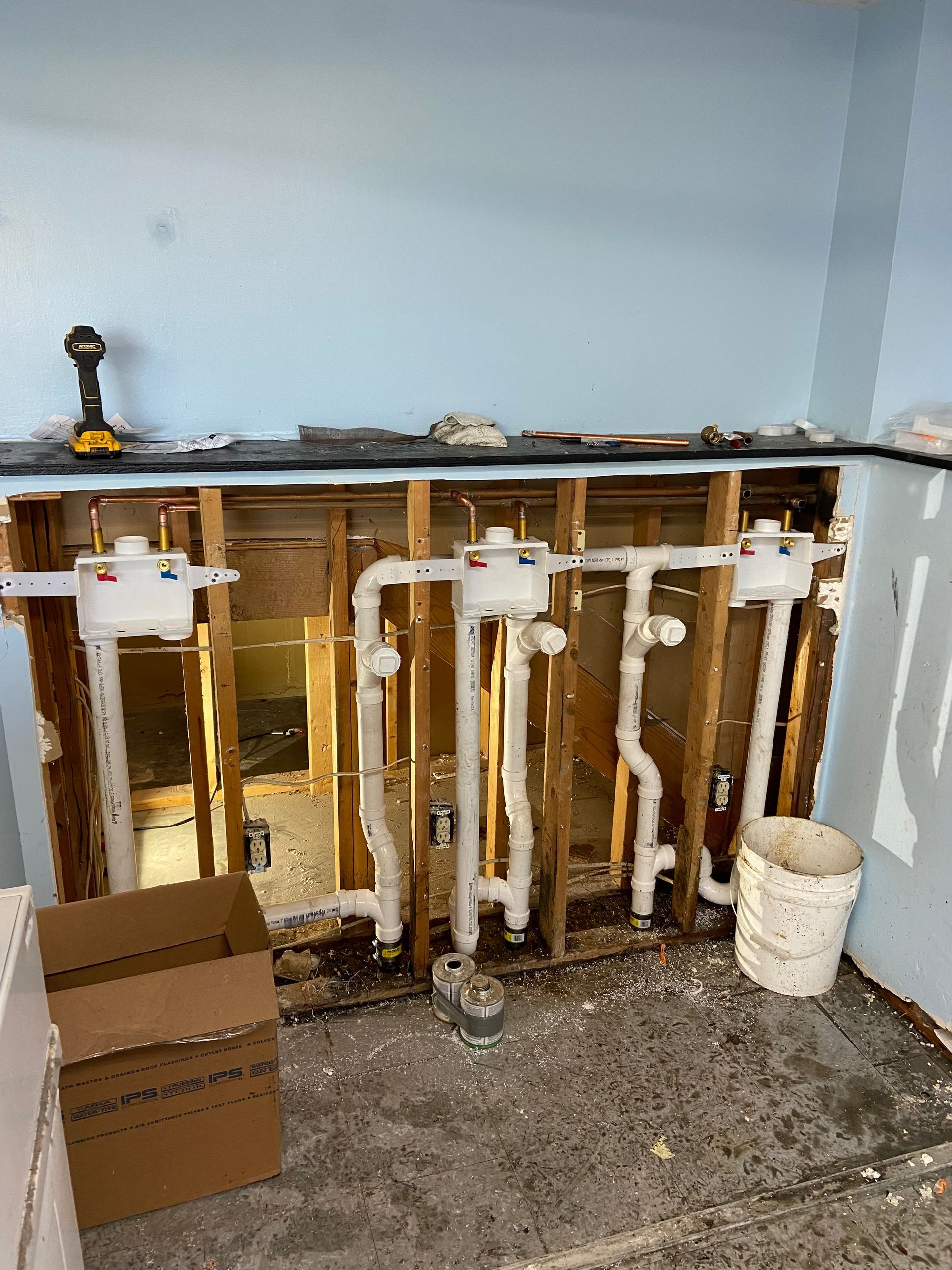 A bathroom with a lot of pipes coming out of the wall.