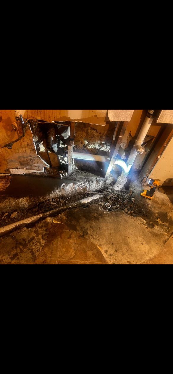 A person is welding a pipe in a basement.