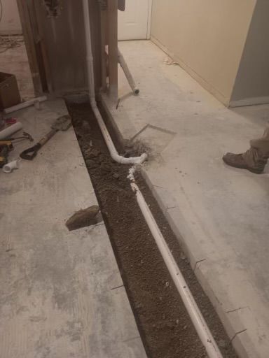 A drain pipe is being installed in a basement