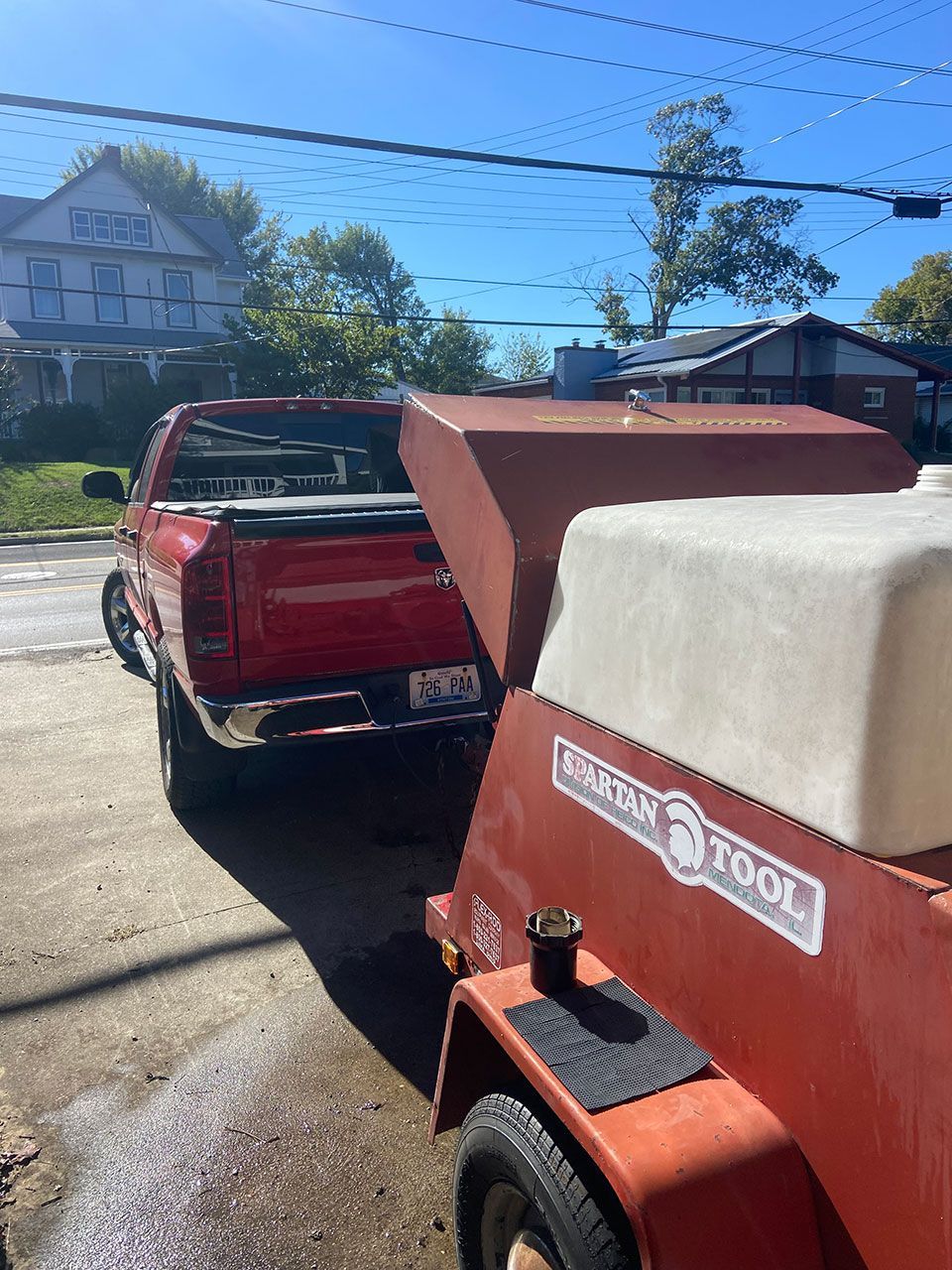 A red truck is parked next to a red trailer