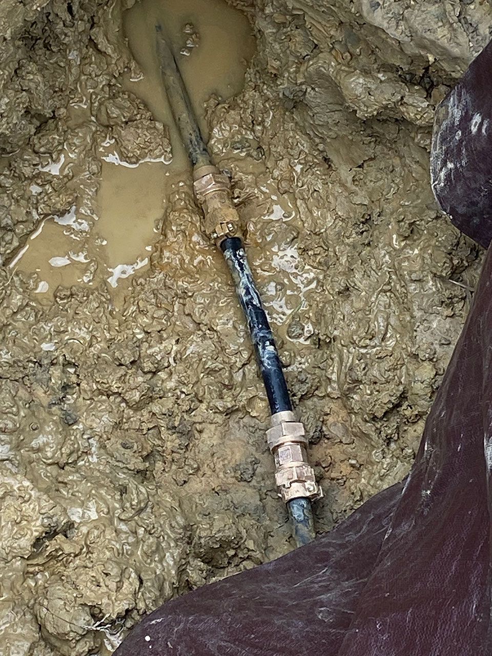 A hose is stuck in a pile of mud