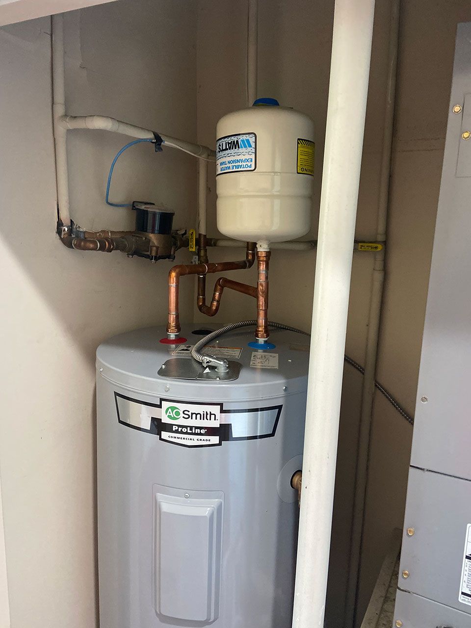 A water heater is sitting in a room next to a wall