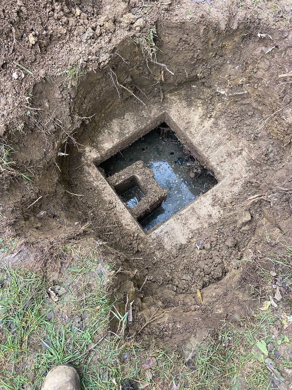 A hole in the ground with water coming out of it