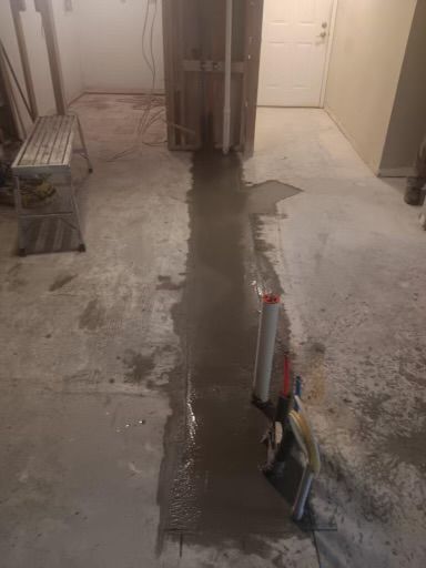 A room with a concrete floor and a pipe in it.