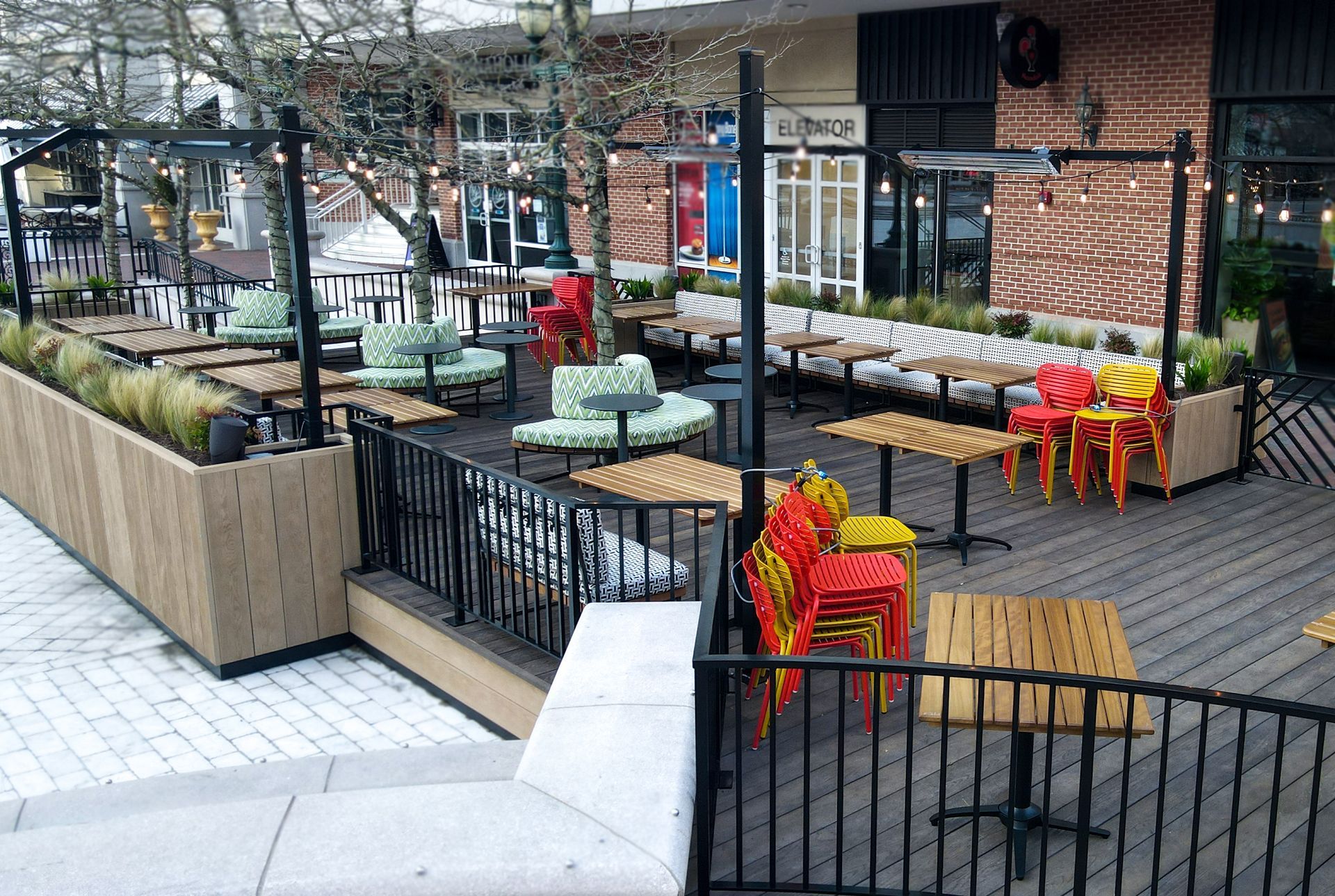 A patio with tables , chairs and umbrellas in front of a building.