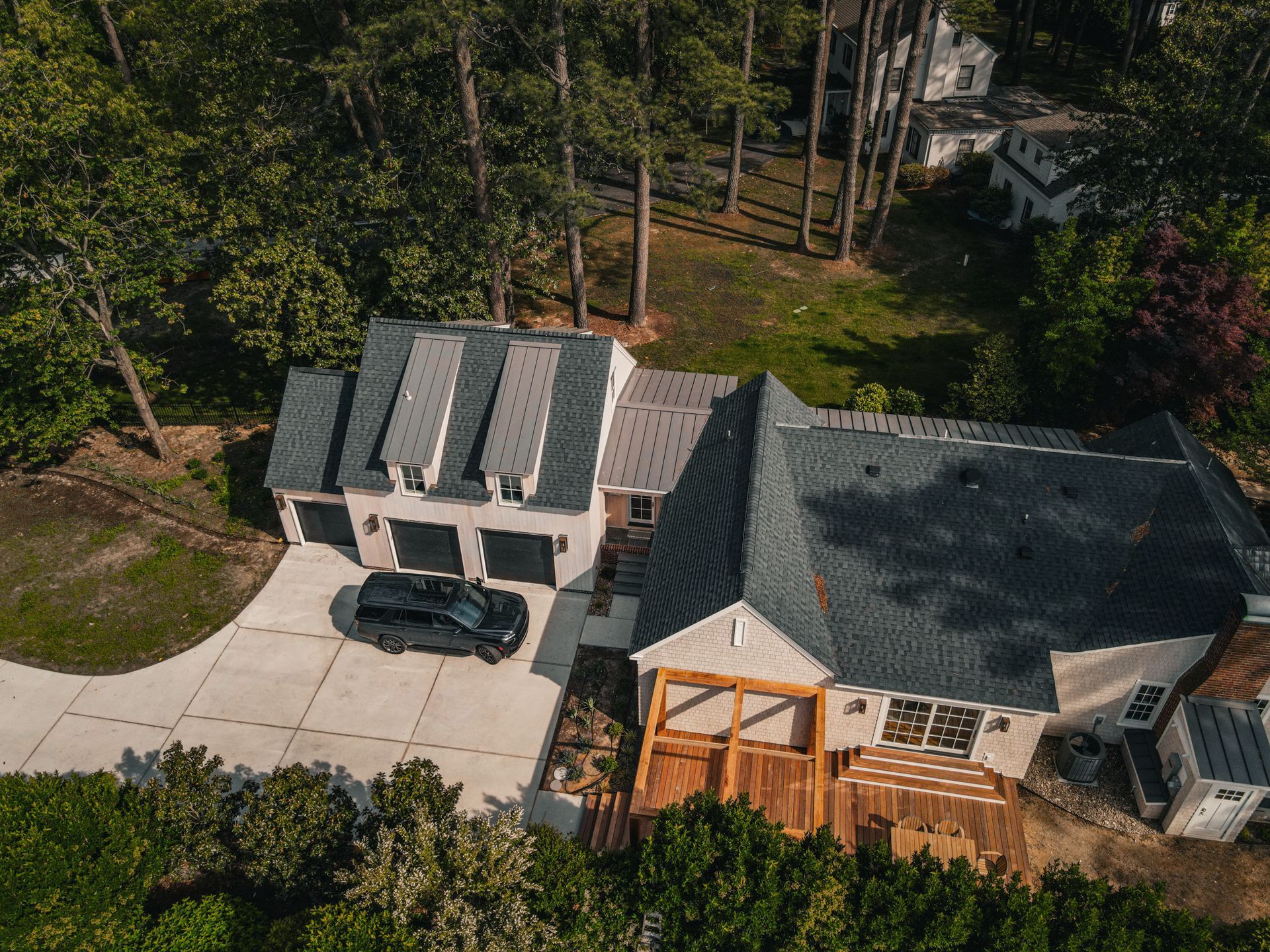 An aerial view of a house with a car parked in the driveway.