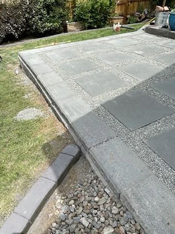 A patio is being built in a backyard.