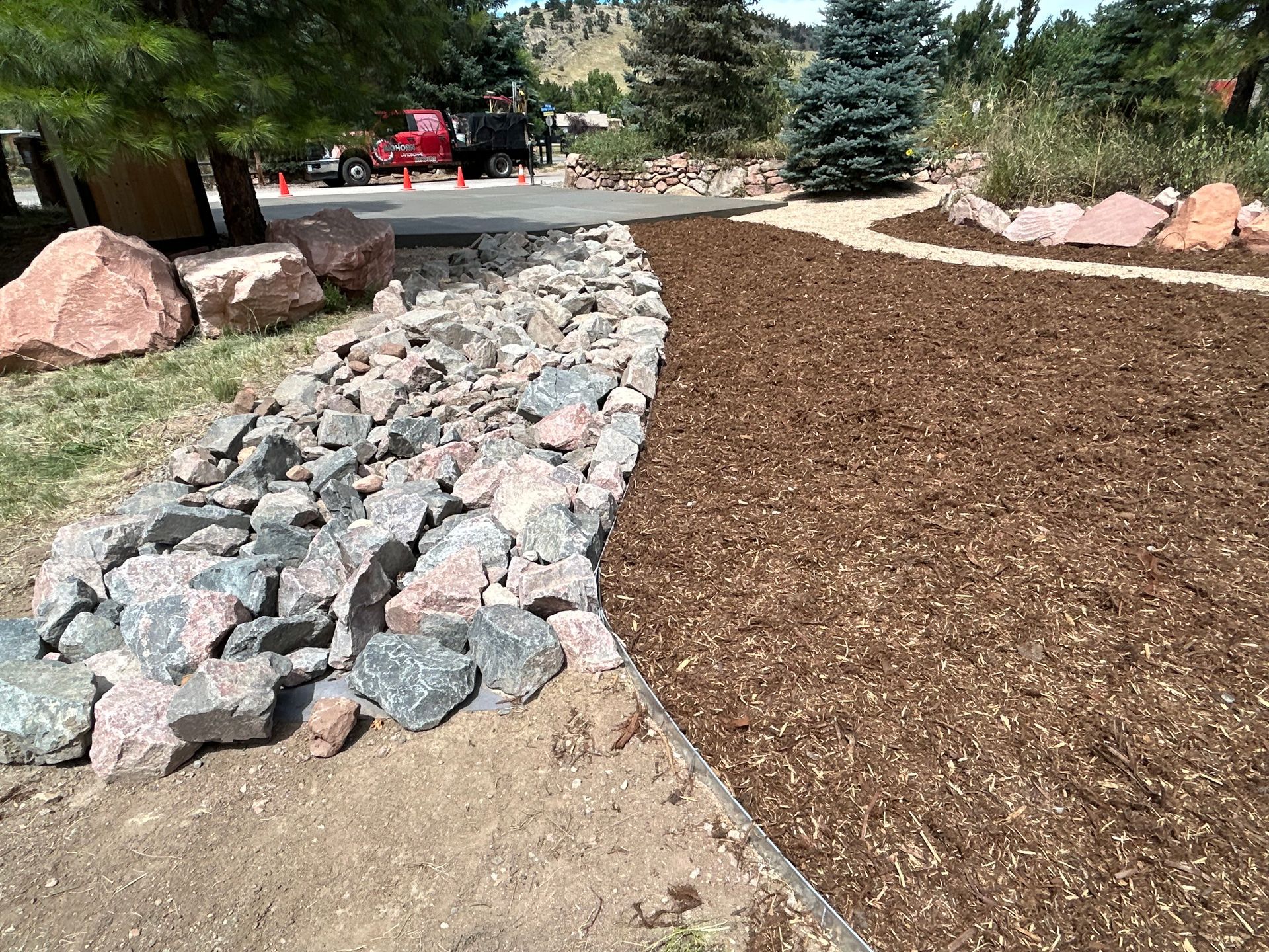 A pile of rocks and mulch next to a road.
