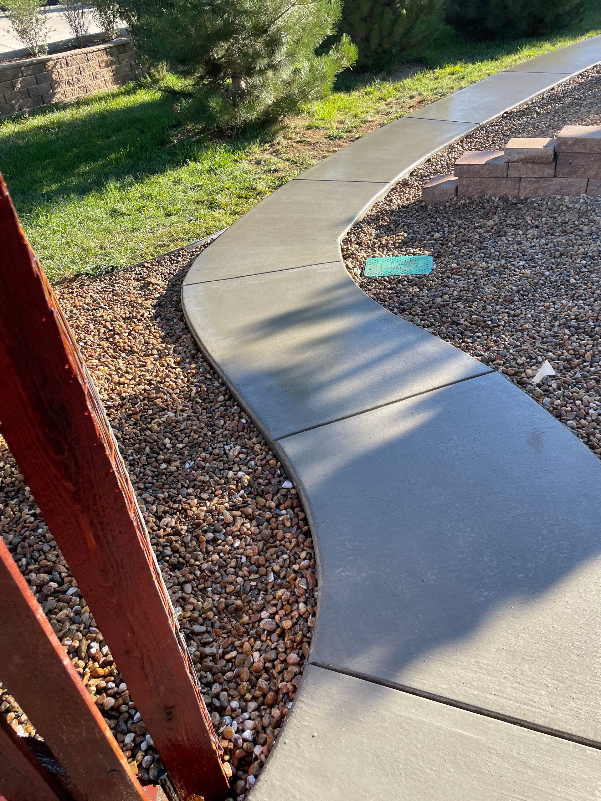 A concrete walkway is surrounded by gravel and grass.