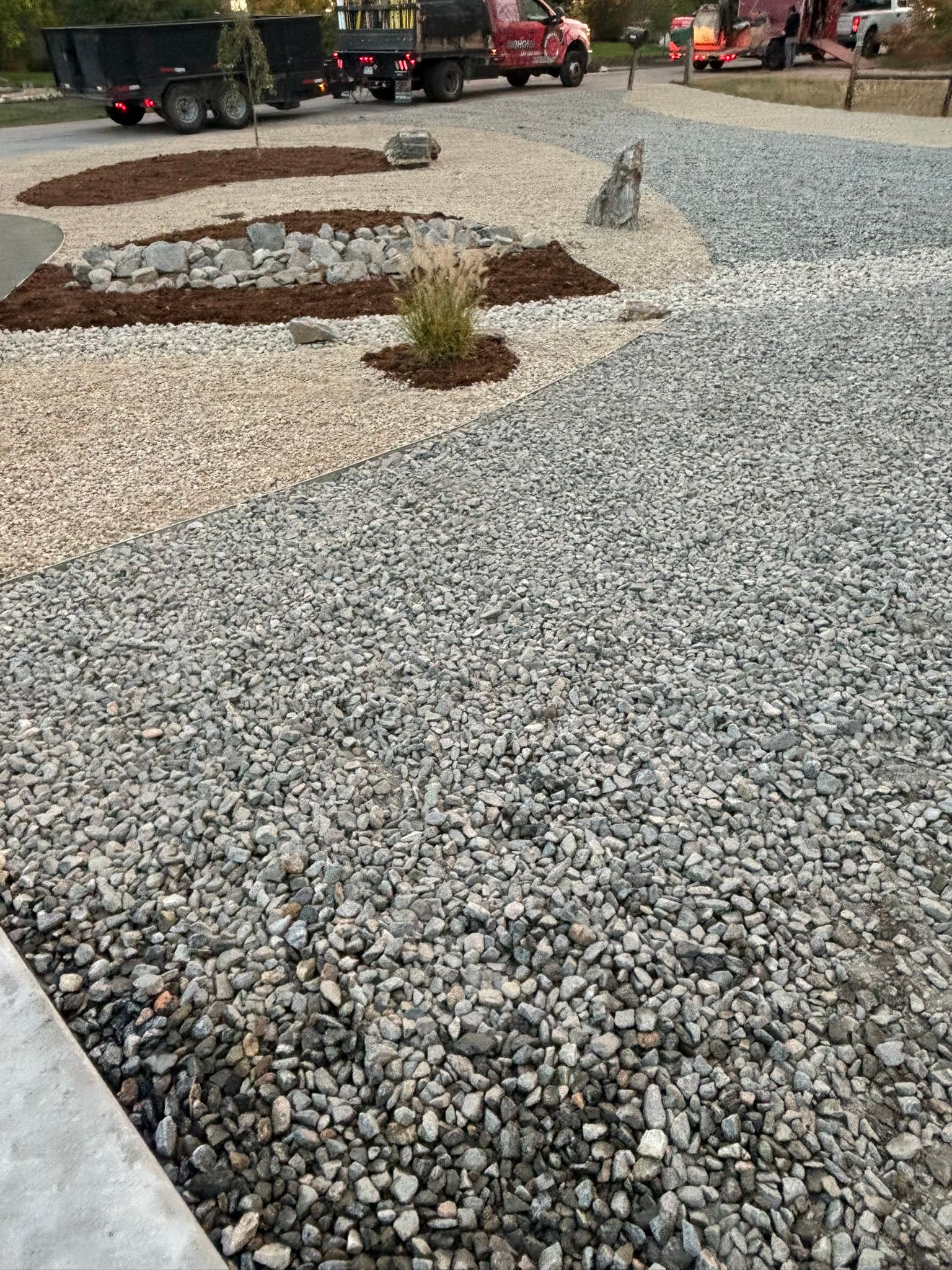 A gravel driveway with a truck parked in the background.