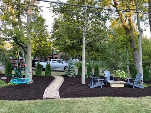 After - A newly maintained backyard with a walkway and a few chairs.