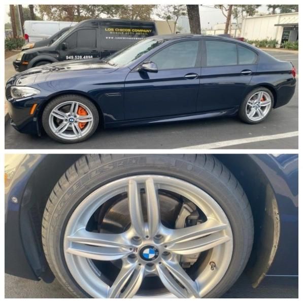 Dark blue BMW sedan on a street, shown in side view and a close-up of a front wheel.