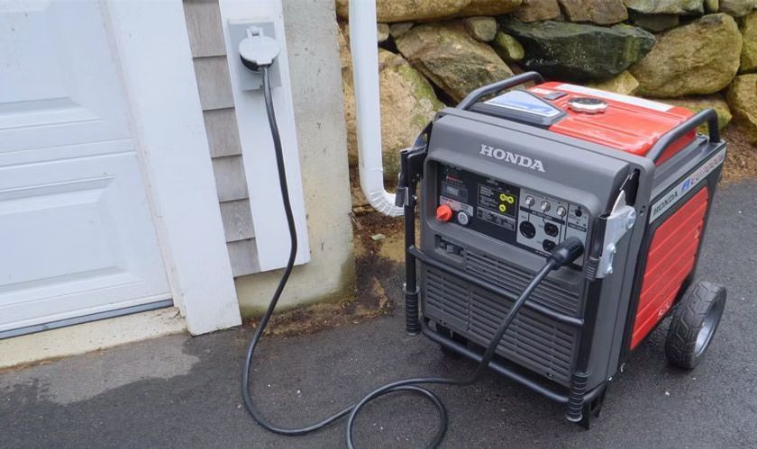 A honda generator is plugged into a garage door.